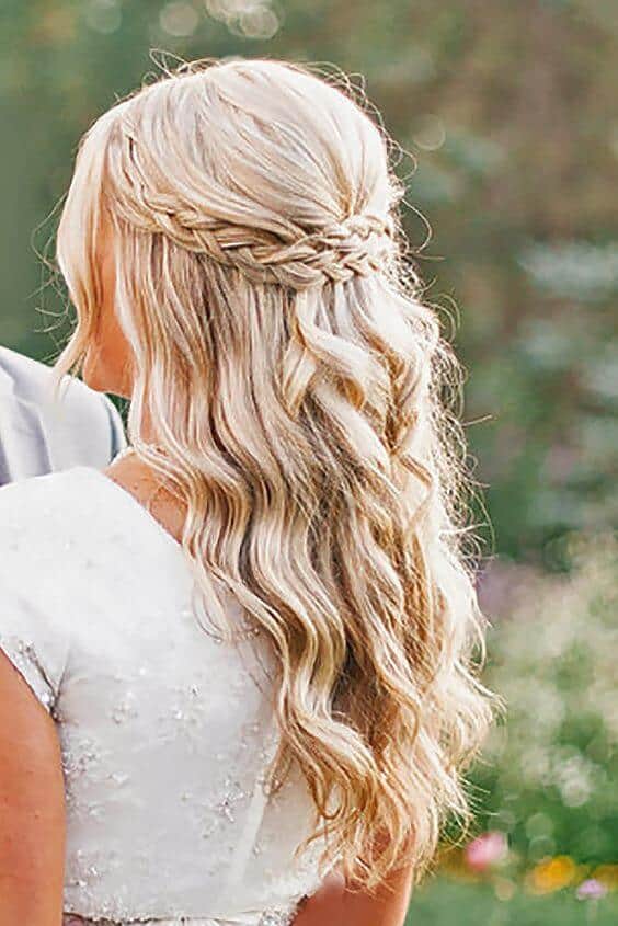 39 popular wedding hairstyles for brides to make your big day perfect 14 Half-up braided bridal hairstyle featuring long, loose beachy waves, captured in a romantic garden setting beside her partner.