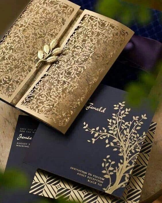41 photo wedding invitations that make hearts skip a beat 32 Opulent navy-and-gold wedding invitation suite featuring a laser-cut botanical gatefold, hot-foil stamped with elegant tree motif.