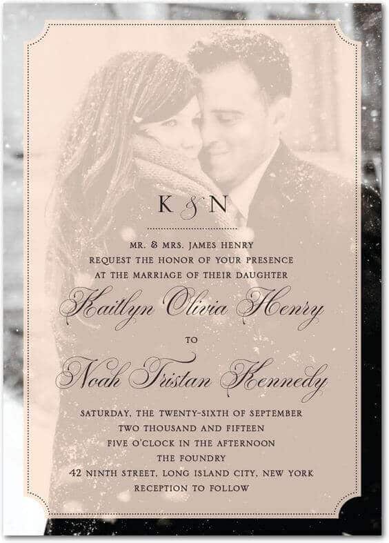 41 photo wedding invitations that make hearts skip a beat 9 Blush-tinted wedding invitation overlaying a sepia photo of a couple in falling snow, featuring elegant calligraphy and a k & n monogram.