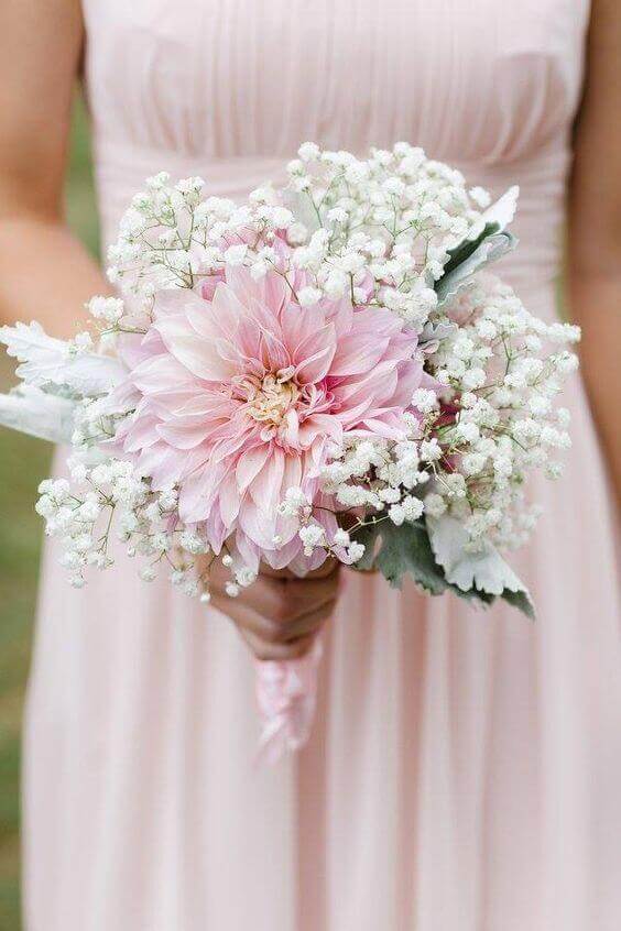 38 wedding accessories list - ideas to transform your big day into magic 18 Blush wedding accessories featuring a bridesmaid bouquet with a pink dahlia, white baby's breath, and dusty miller against a chiffon dress.