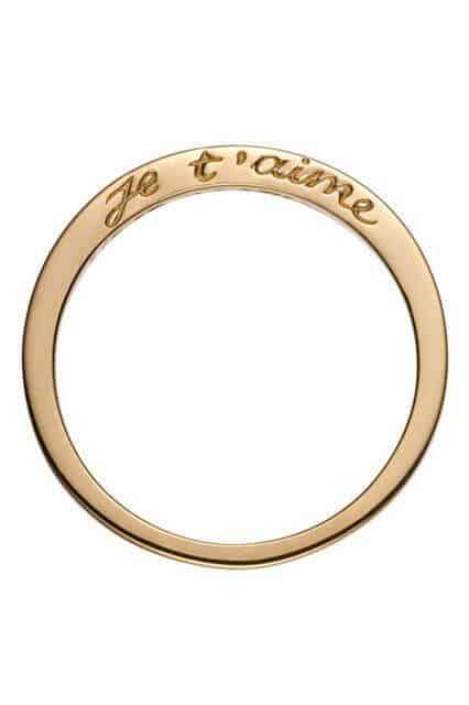 Slim yellow-gold wedding band engraved with 'je t’aime' on a white background, showcasing minimalist elegance and romantic flair.