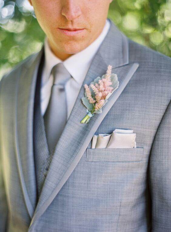 38 wedding accessories list - ideas to transform your big day into magic 24 Refined wedding accessories feature a groom in a soft dove grey suit, complemented by a silver satin tie and blush astilbe boutonniere.