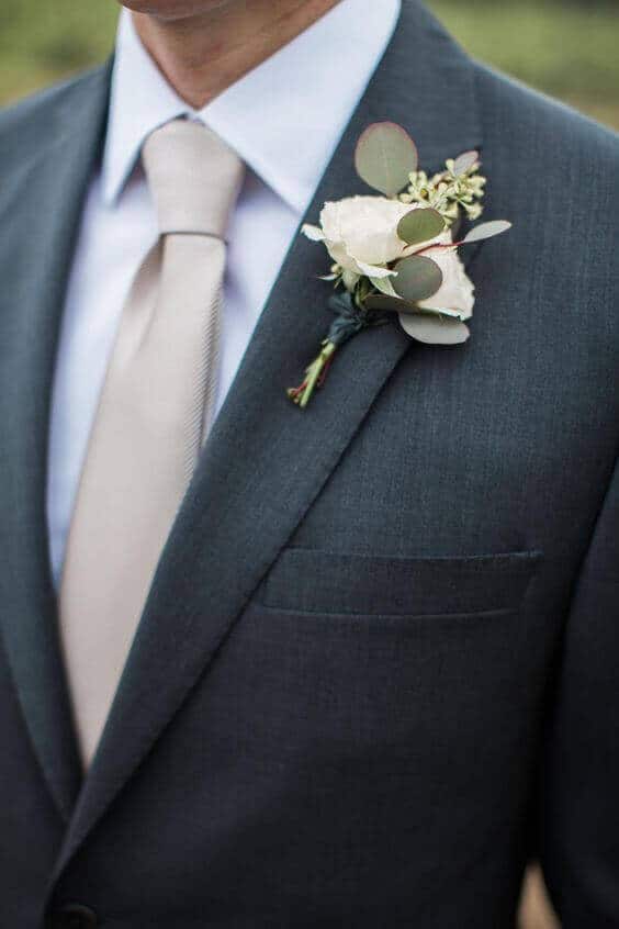 38 wedding accessories list - ideas to transform your big day into magic 26 Elegant wedding accessories featuring pearl earrings and a crystal tiara, complemented by a soft champagne tie and a white rose boutonniere.